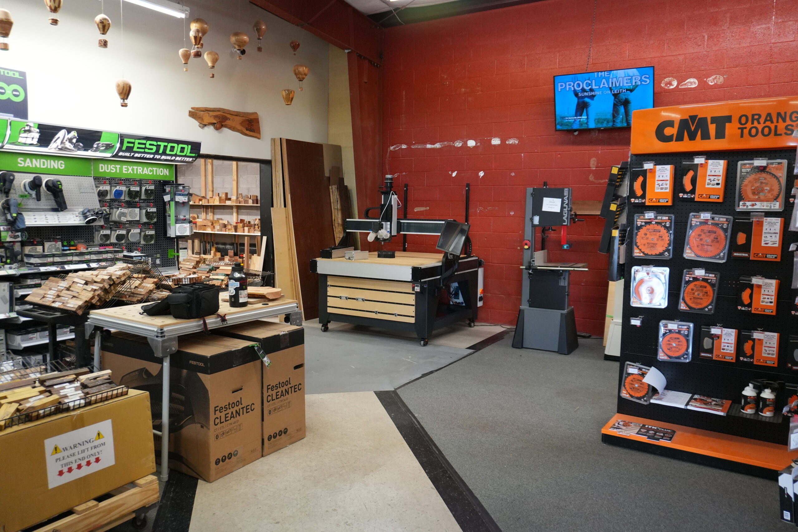 Fusion Pro CNC machine installed at Exotic Woods in Albuquerque, New Mexico, featuring black rolling, steel stand and wasteboards, touchscreen controller, dust collection system, vertical work holdin i a professional workshop setting