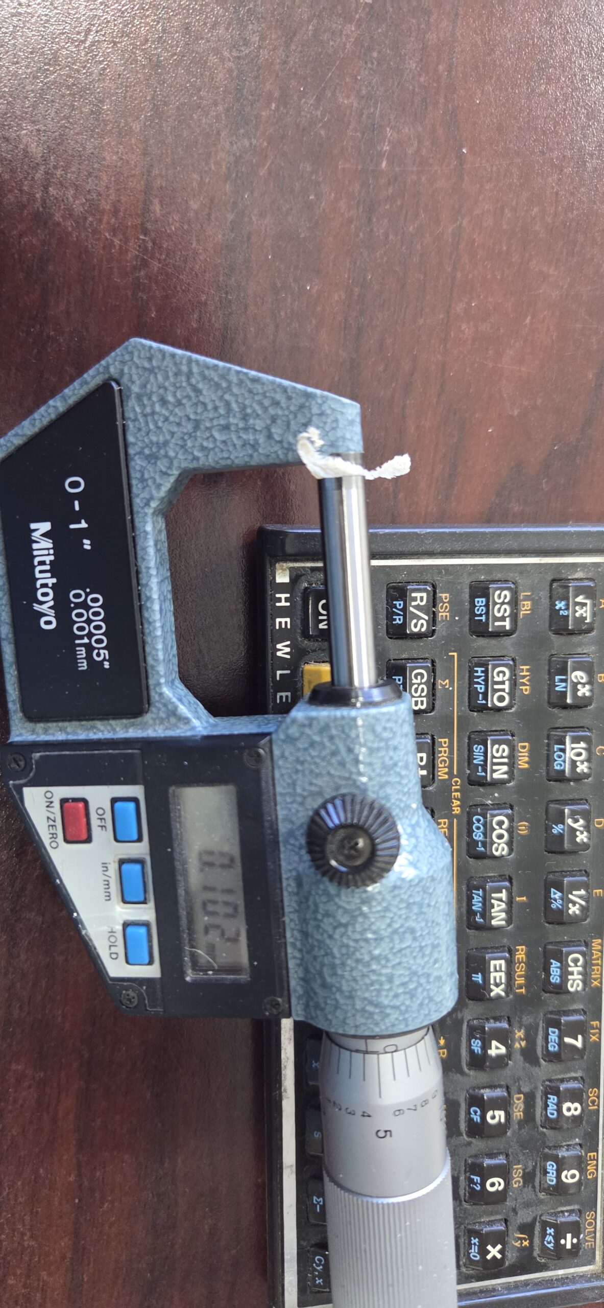 Micrometer measuring thickness of a wood chip carved on the Fusion Pro CNC
